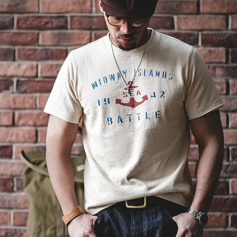 Man wearing a t-shirt with a graphic design in front of a brick wall